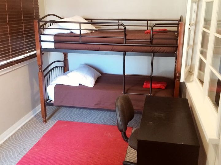 A bedroom with bunk beds and a desk.